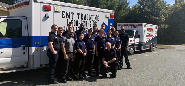 students posing in front of the emt training vehicle