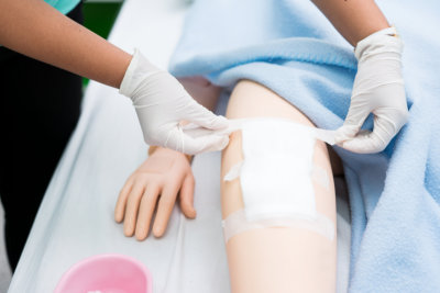 a trainee putting bandage on a dummy